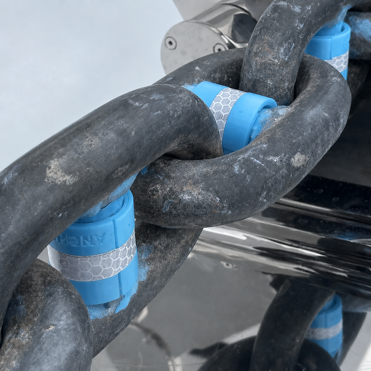 Close up of light blue stud link chain markers fitted to anchor chain