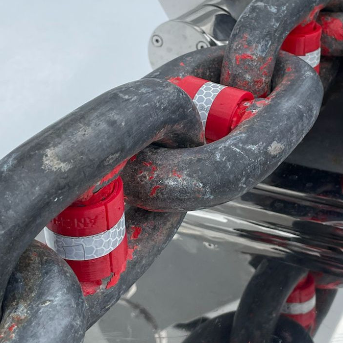 Close-up of a chain with 40mm red stud links and reflective tape